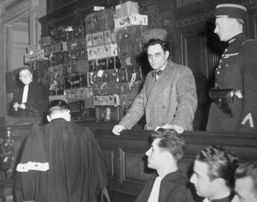 Photo: Marcel Petiot dans le box des accusés lors de son procès aux Assises. À sa droite, les pièces à conviction.